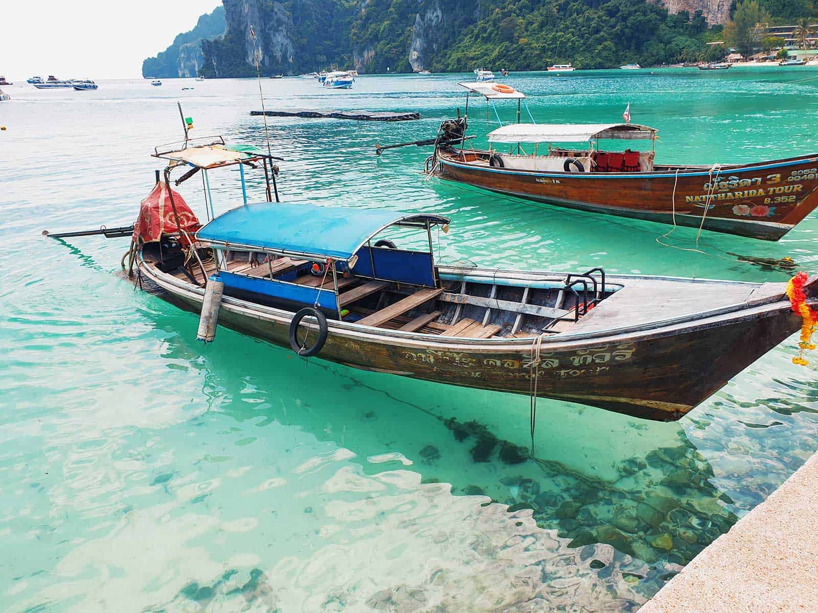Kayaks and longtail boats on a tropical Thailand beach